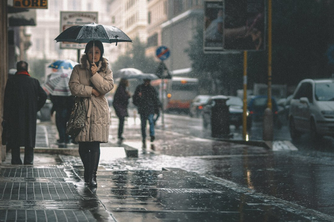 woman detective walking in rainy city street